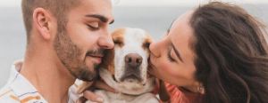 couple kissing pet dog